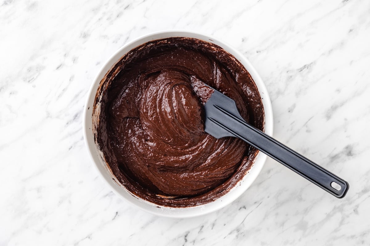 mixing the flour into the brownie batter with a silicone spatula.