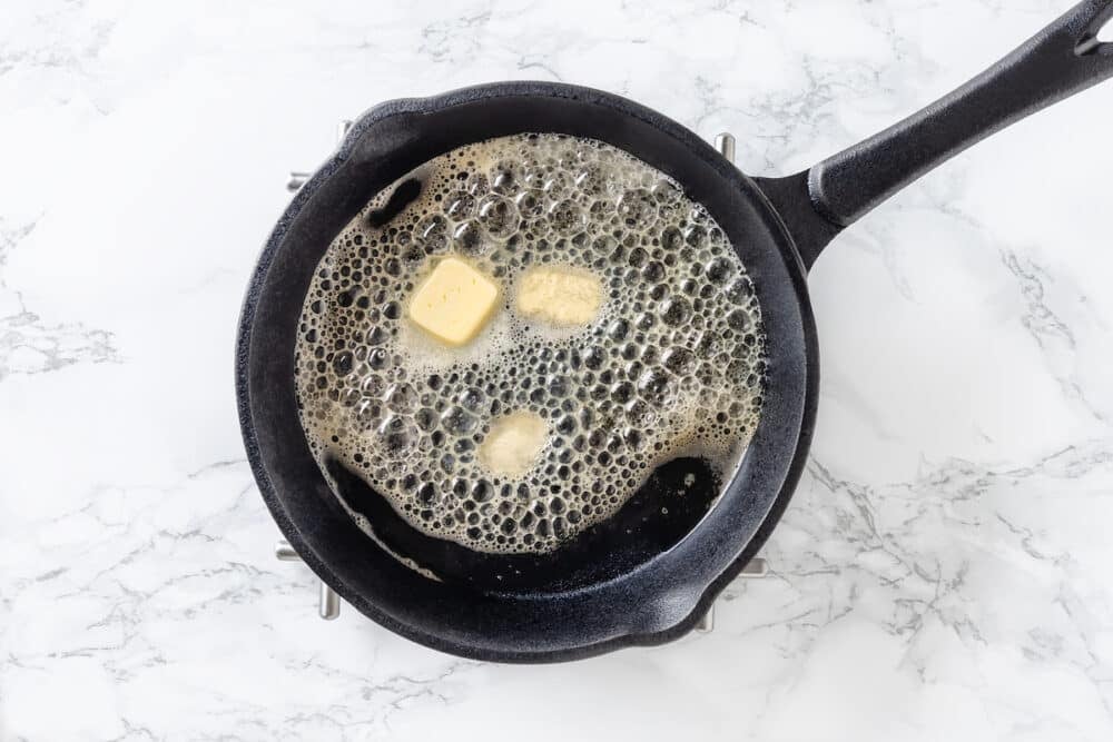 butter melting and sizzling in a hot cast iron skillet.