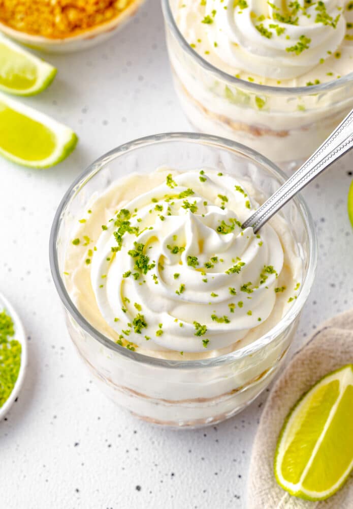 whipping cream with zest on individual clear glass key lime dessert.