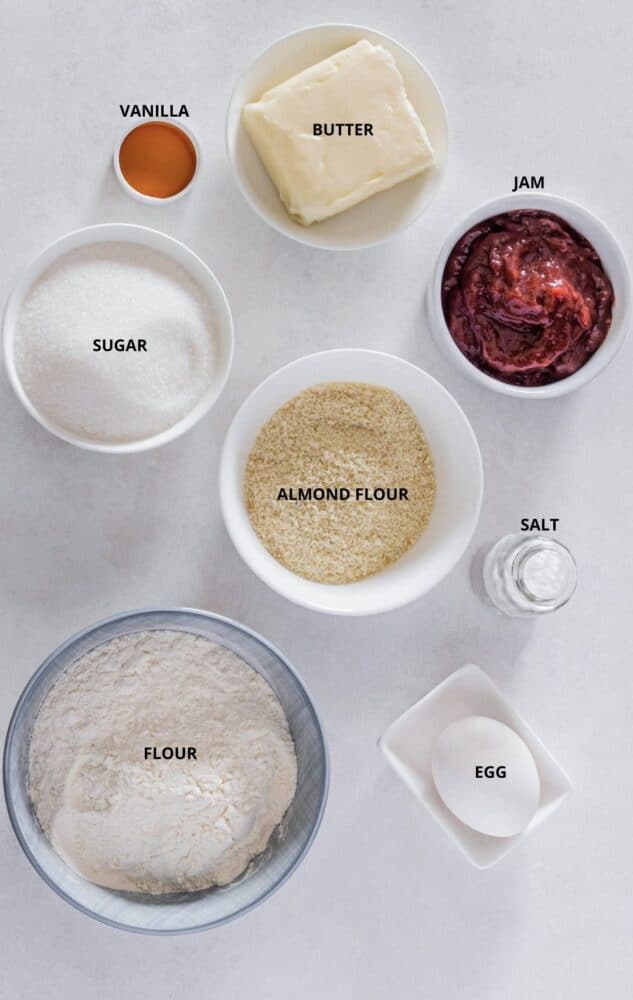 Thumbprint cookies with jam ingredients vanilla, butter, jam, almond flour, sugar, salt, egg, and flour.