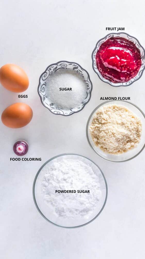 macaron ingredients spread fruit jam, sugar, almond flour, powdered sugar, food coloring, and eggs.