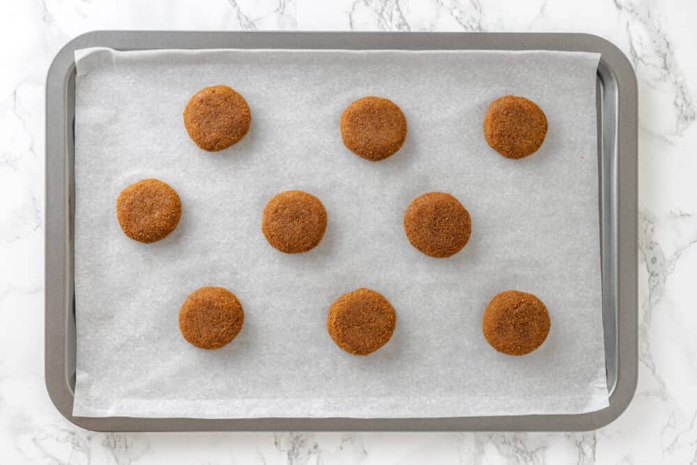 Almond snickerdoodle cookies ready to bake on parchment paper and a cookie sheet.