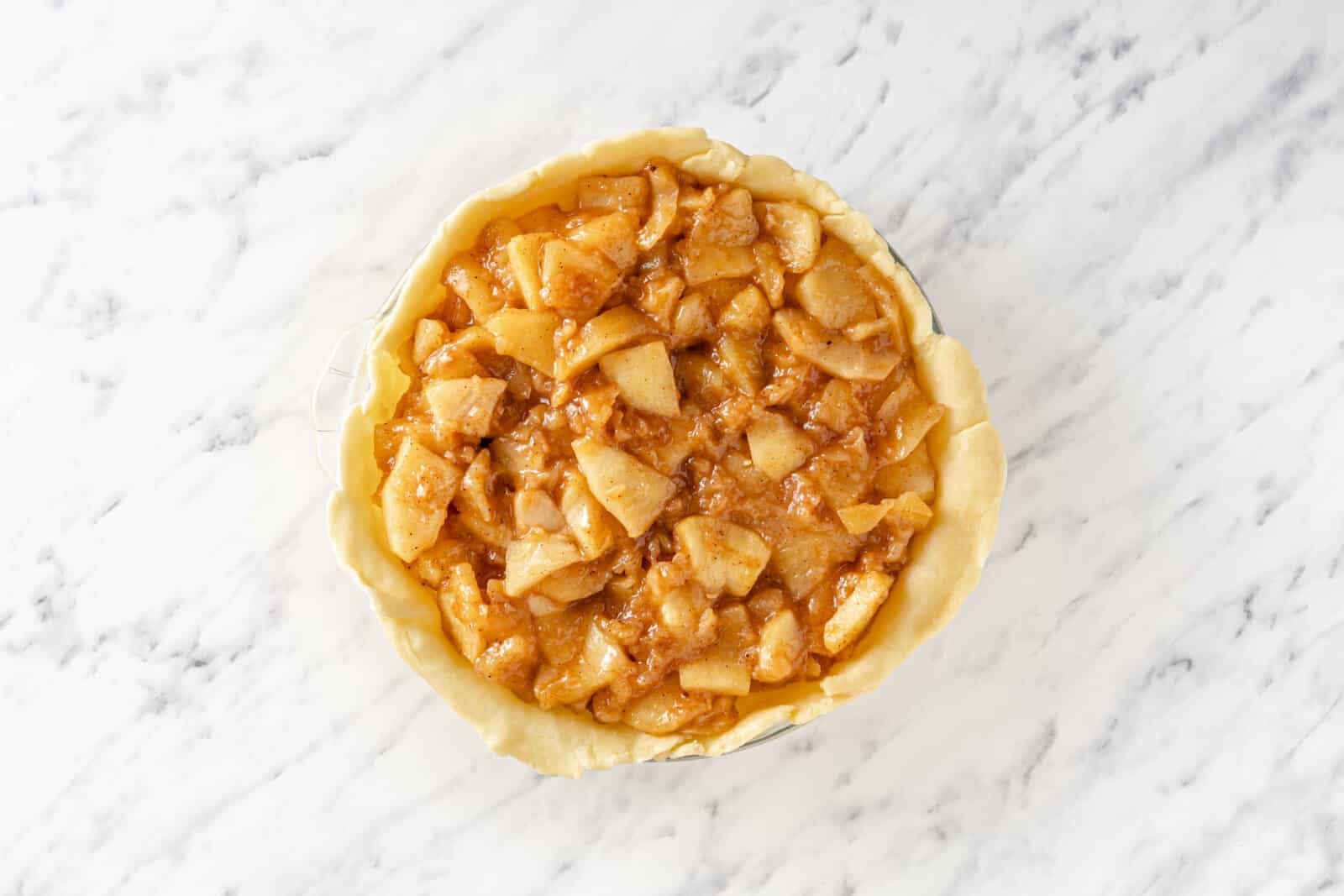 Apple pie filling added to pie crust.