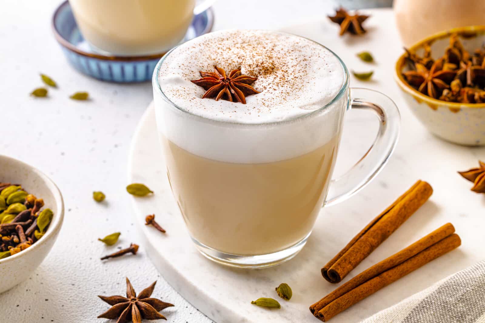 Chai tea latte with frothy milk on top and star anise for garnish.