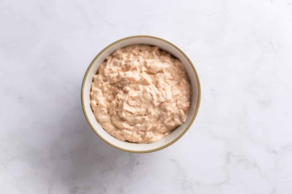 Salmon Sushi Bake with Spicy Mayo Cooked salmon mixed with spicy mayo and cream cheese in a bowl.