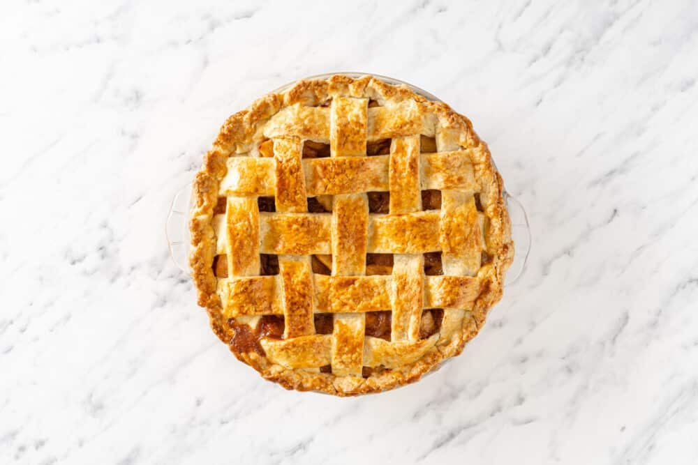 Freshly baked apple pie in a glass pie tin.