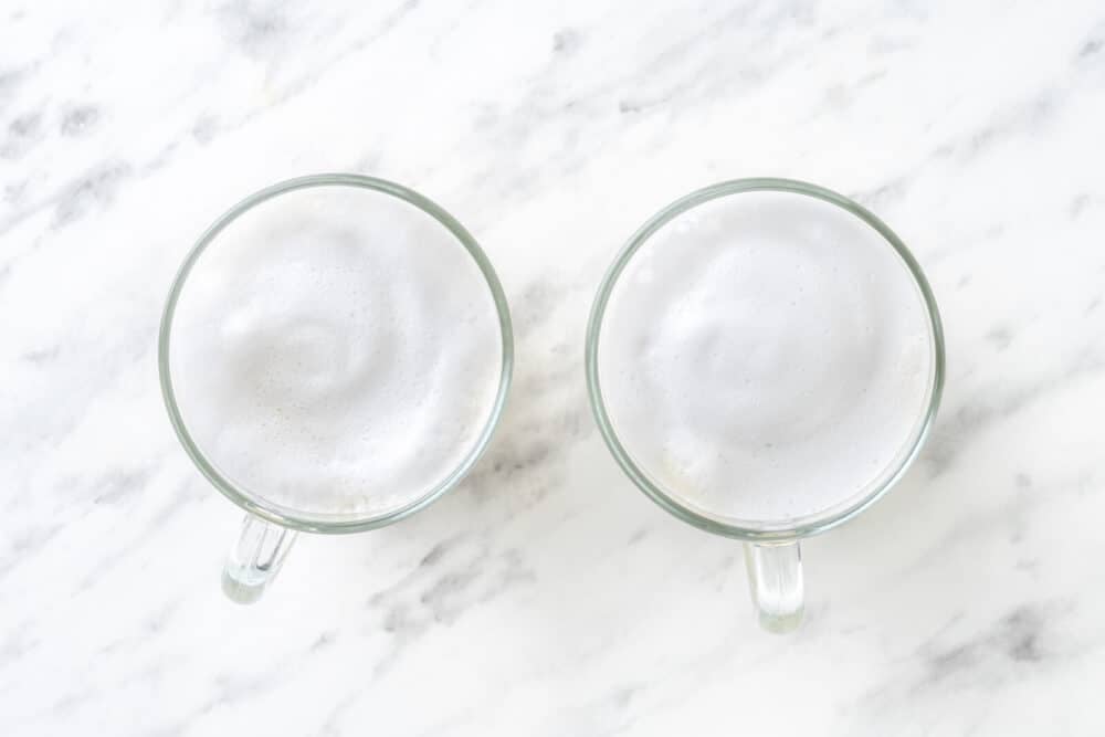 Frothy milk poured on top in a glass mug.