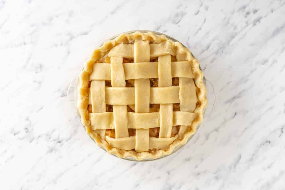 Latticed pie ready to bake in a pie tin.
