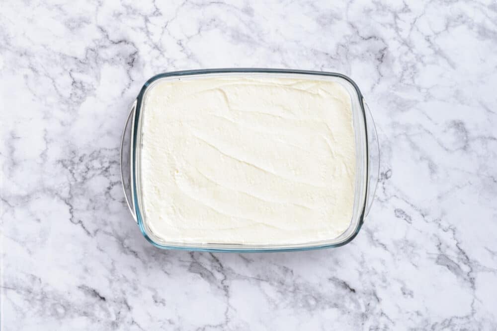 Middle cream layer for strawberry jello pretzel salad in a baking dish.