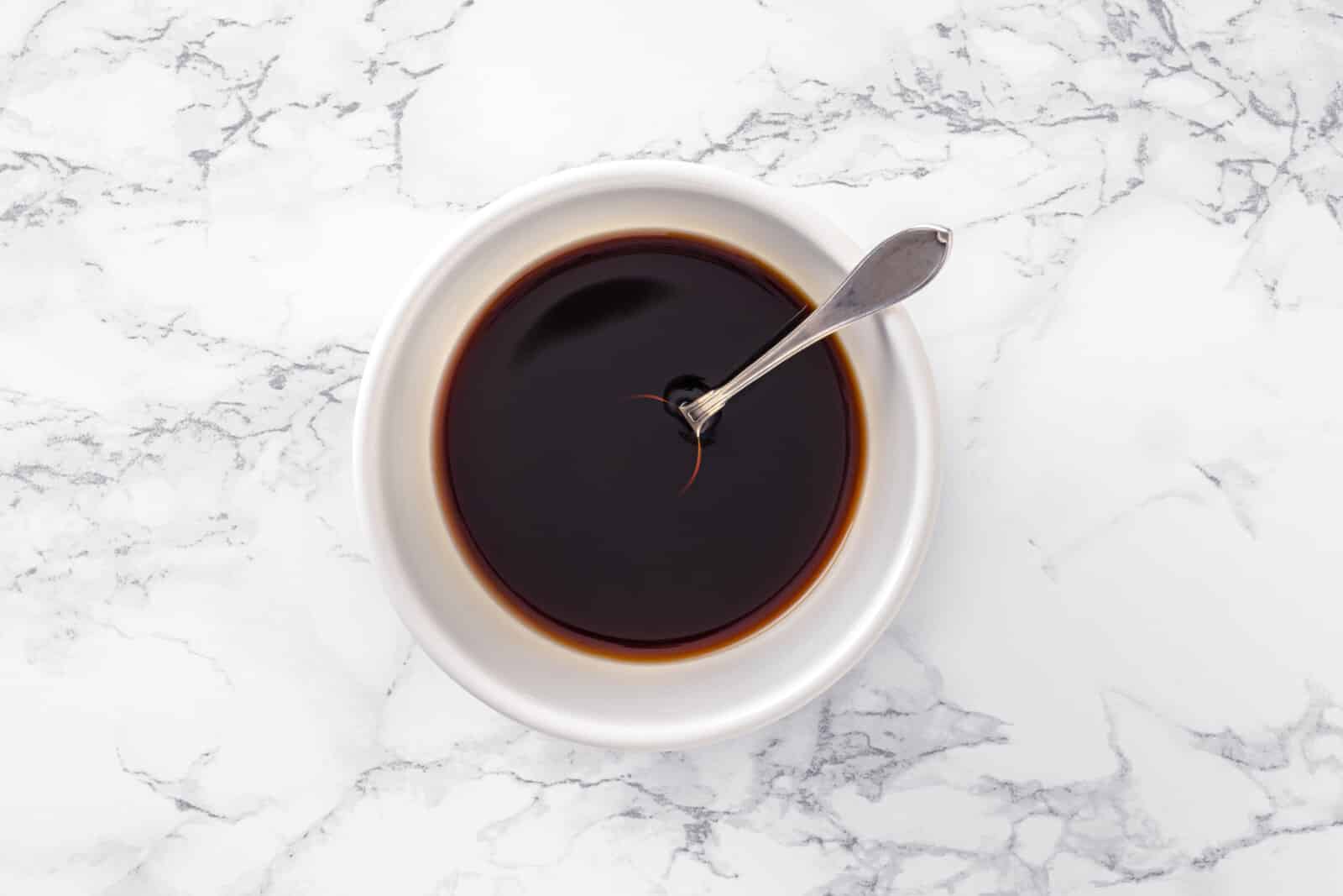Mixing dressing in a white bowl with a spoon.