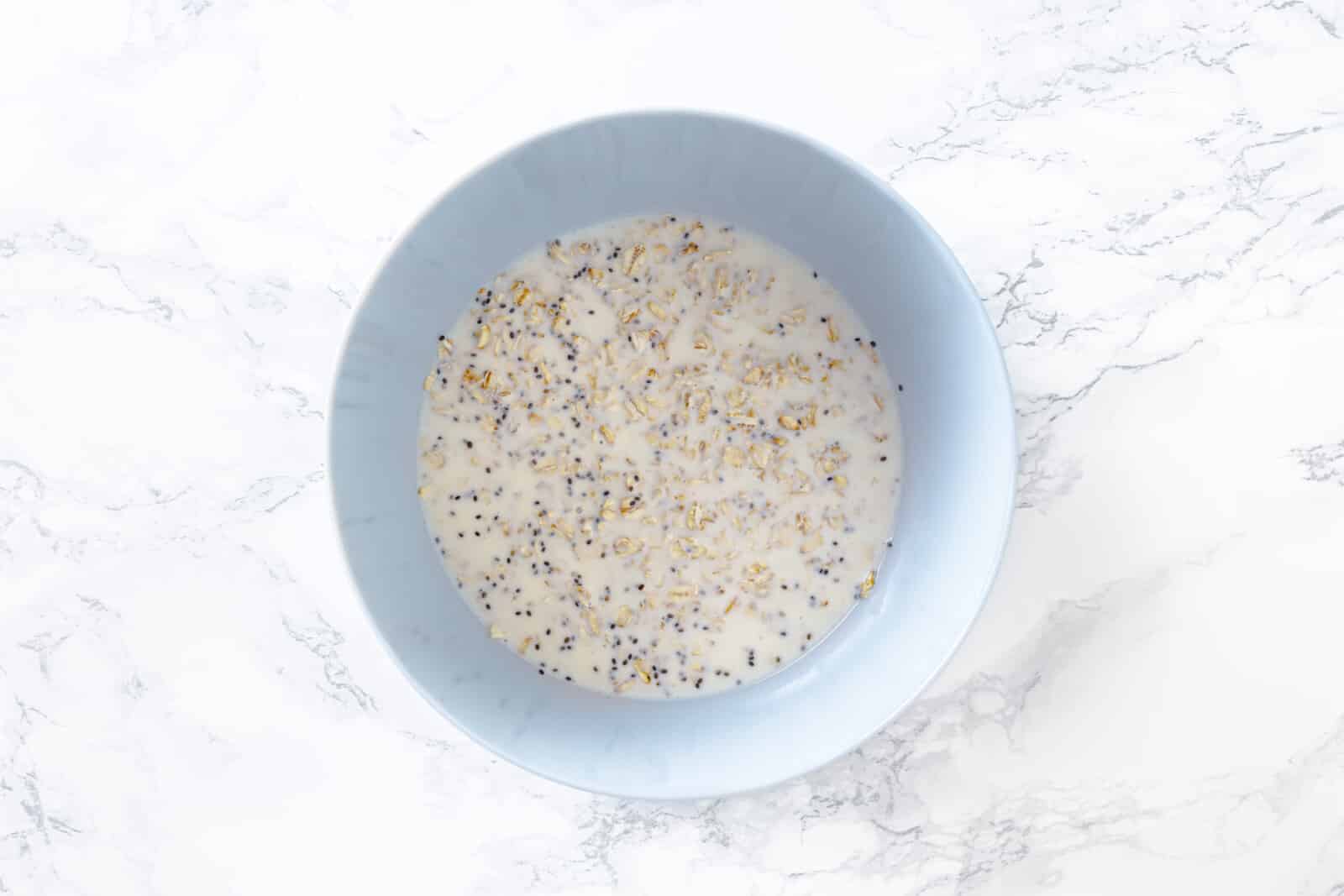 Overnight oat mixture put together in a blue bowl.