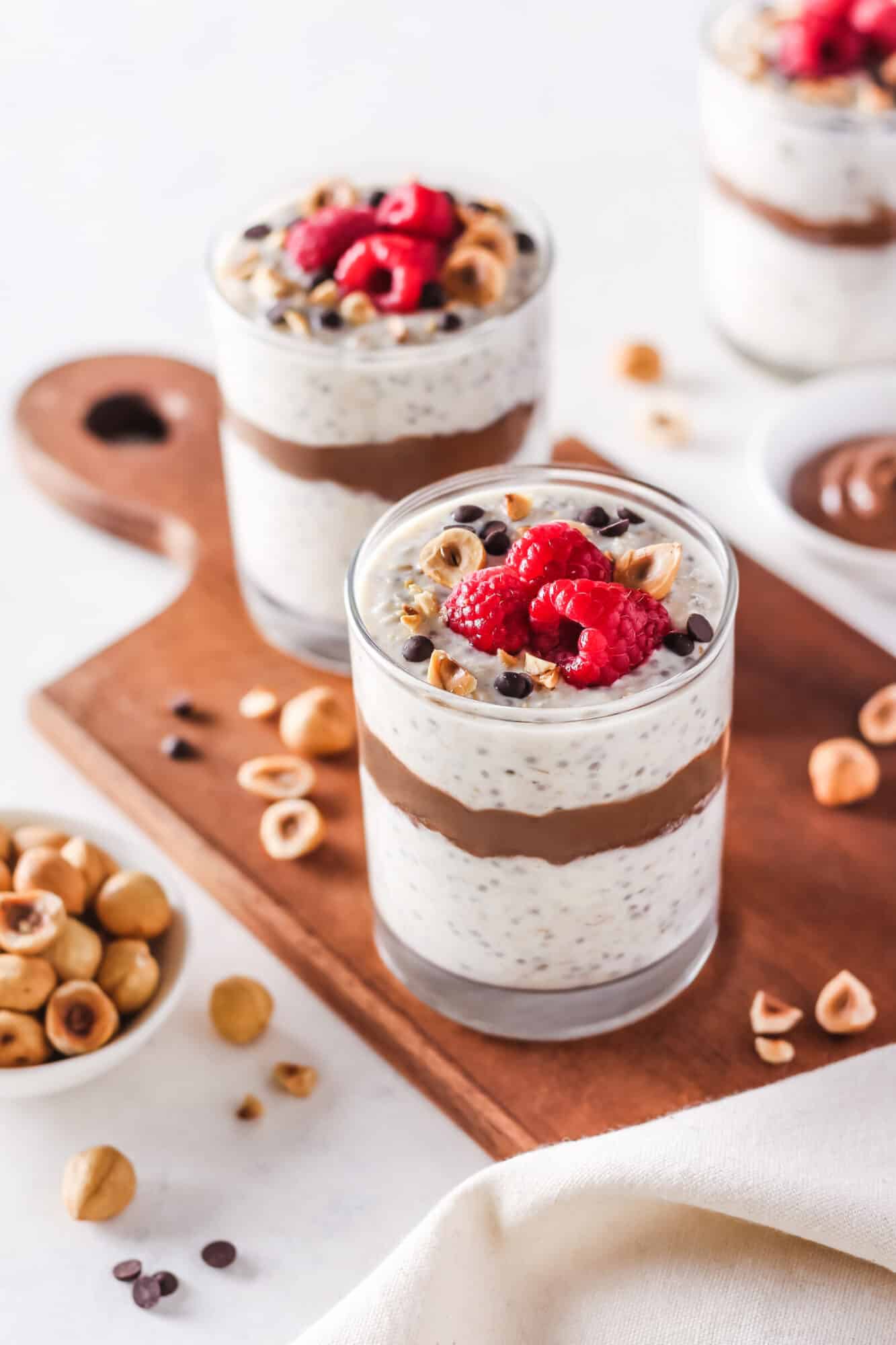 Overnight oats with hazelnut cocoa layered in the center, topped with berries.
