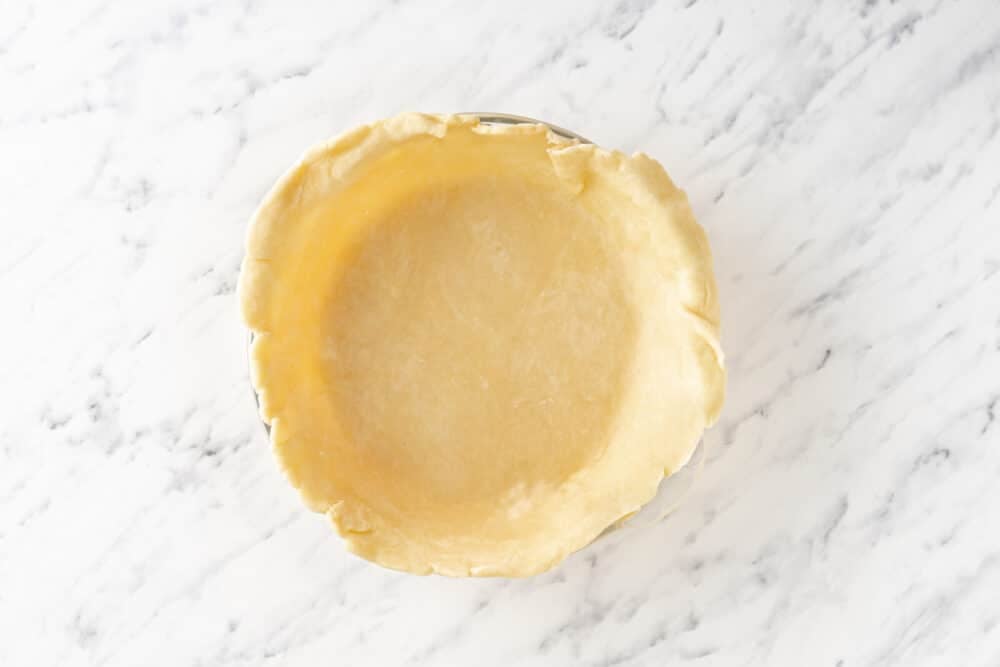 Pie crust in a pan, ready to bake.
