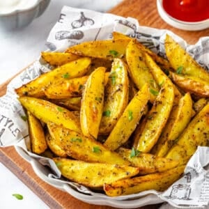 Ready to eat potato wedges in a bowl with paper.