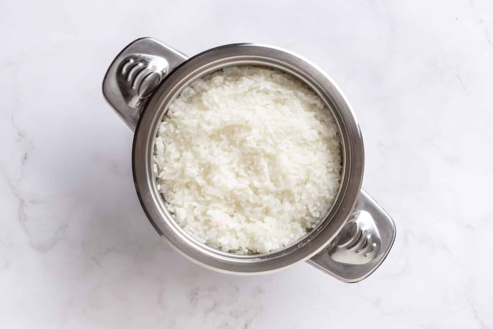 Salmon Sushi Bake with Spicy Mayo Rice cooked in a silver pot with handles.