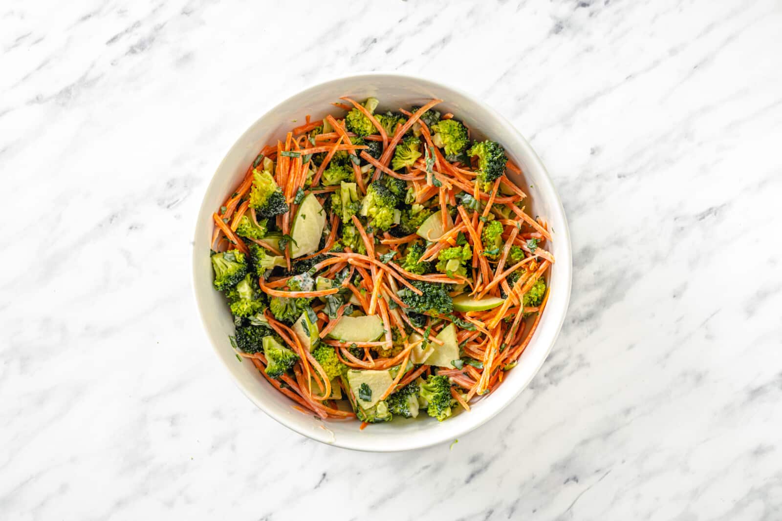 Salad ingredients combined in a bowl, mixed with mayonnaise.