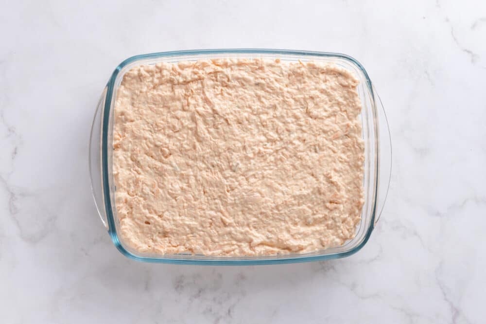 Salmon Sushi Bake with Spicy Mayo Salmon layer over rice in a large baking pan.