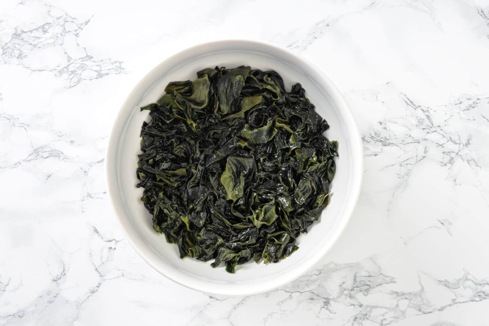 Soaked wakame in a white bowl.