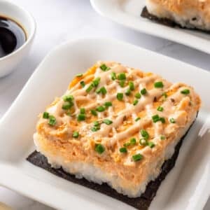 Salmon Sushi Bake with Spicy Mayo Sushi bake slice with nori and chopsticks.
